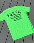Neon green t-shirt with black text on a wooden surface