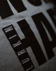 Close-up of a textured t-shirt with embossed text and logo.