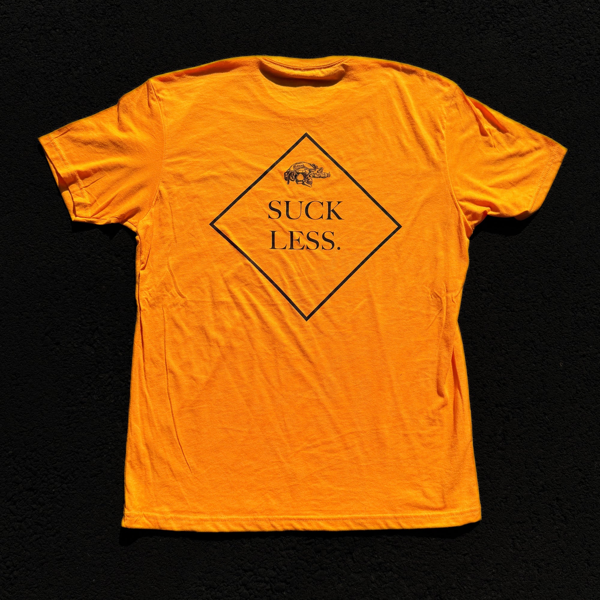 Orange t-shirt with 'Suck Less' graphic on a black background