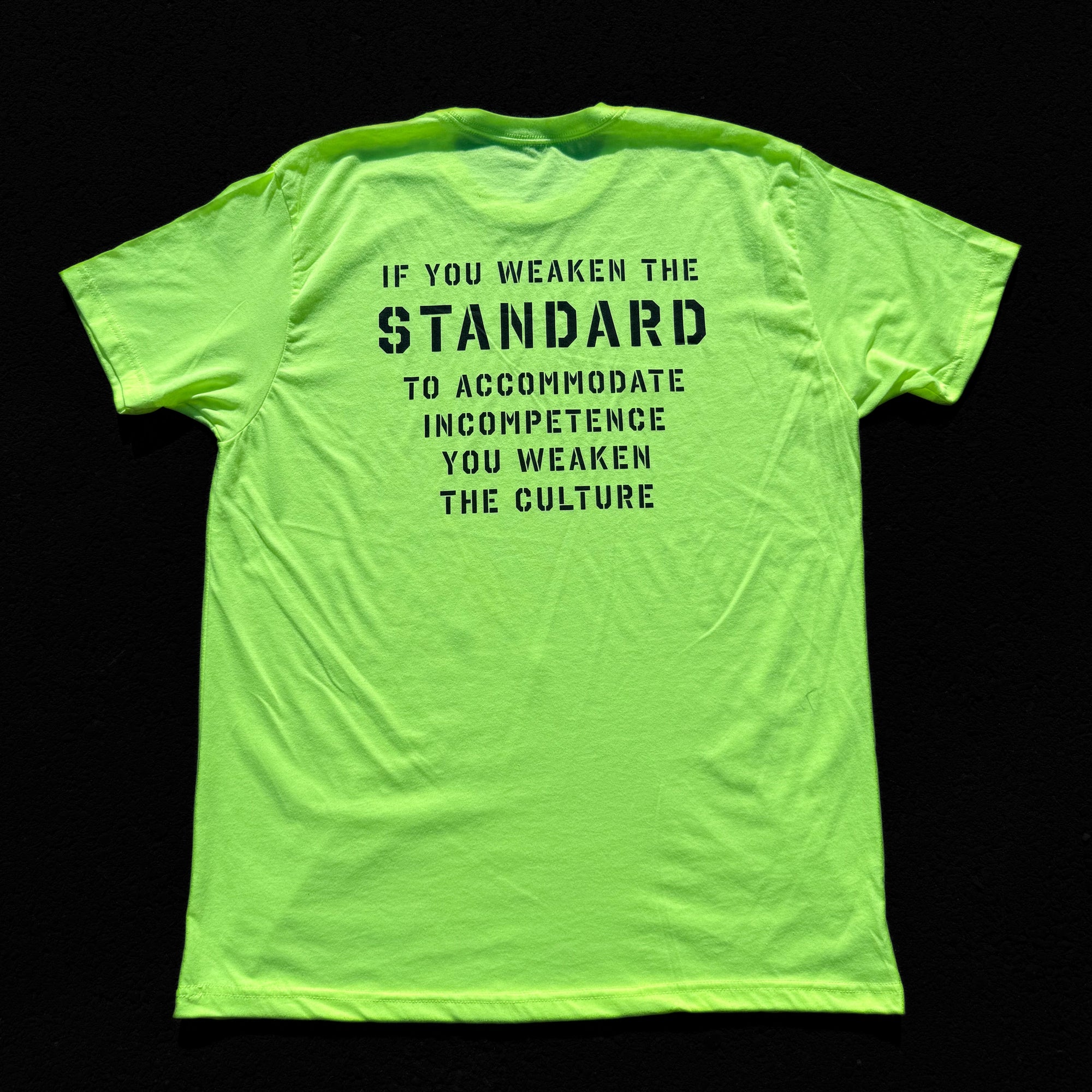 Bright yellow t-shirt with black text on a black background
