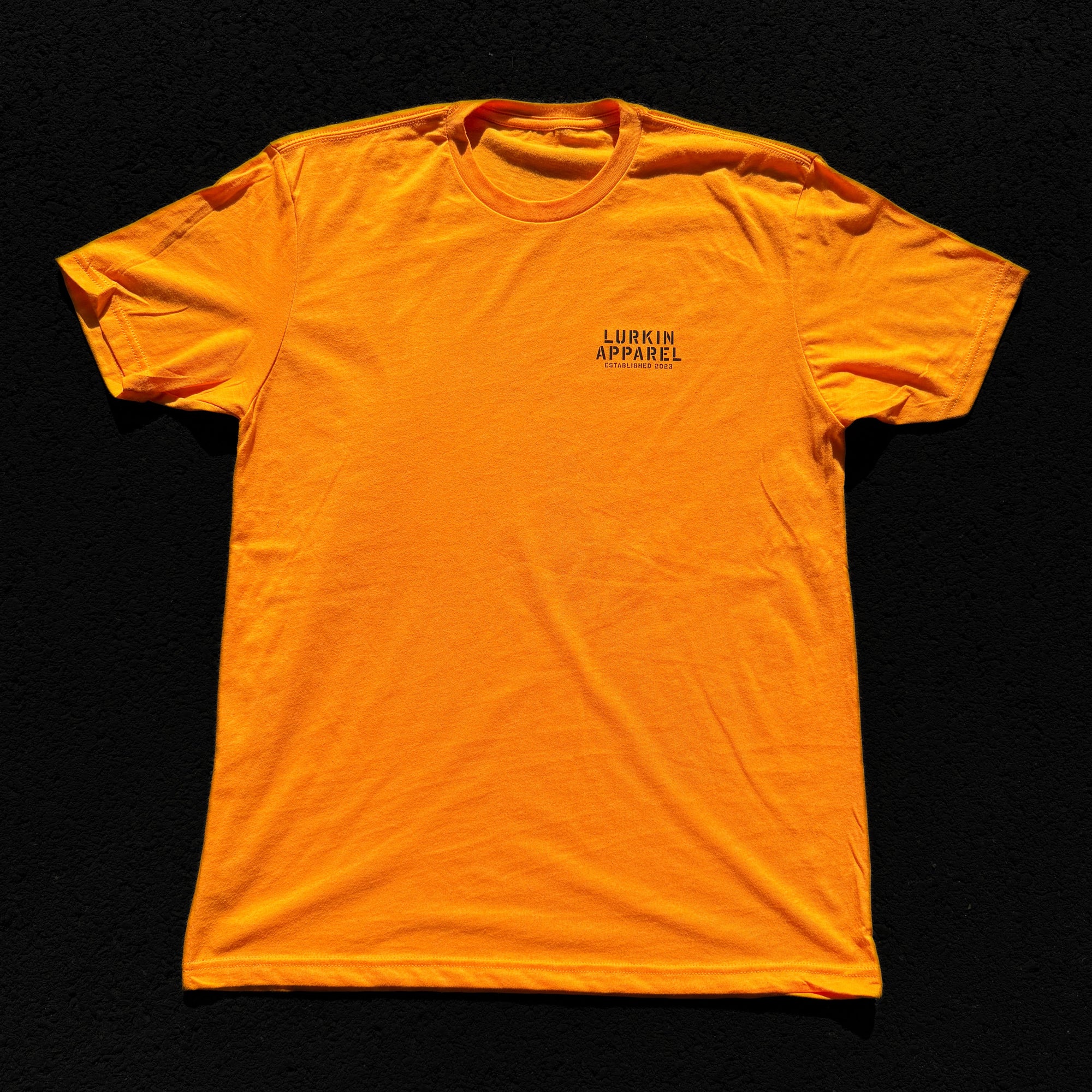 Orange t-shirt with a brand logo on a black background