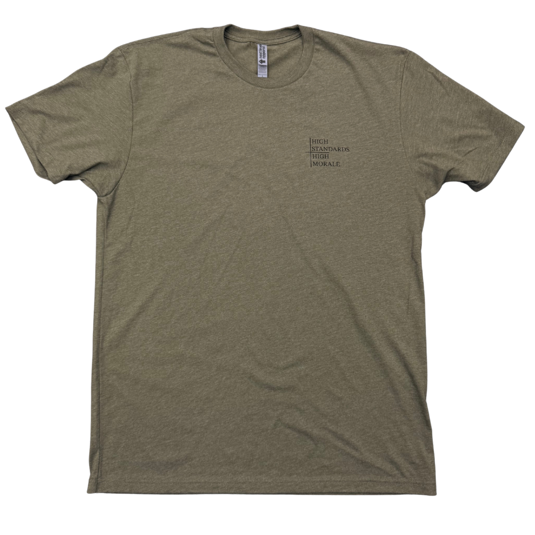 An olive green short-sleeve t-shirt with a small black text graphic, high standards high morale on the left chest, displayed flat against a white background.