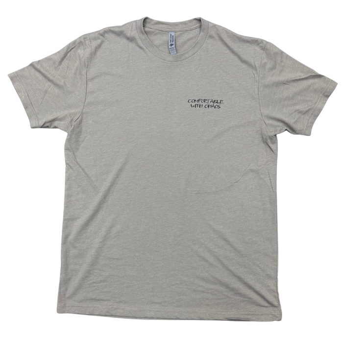 A stone gray crewneck t-shirt with a small black 'Comfortable with chaos' logo printed on the left chest, displayed flat against a white background.