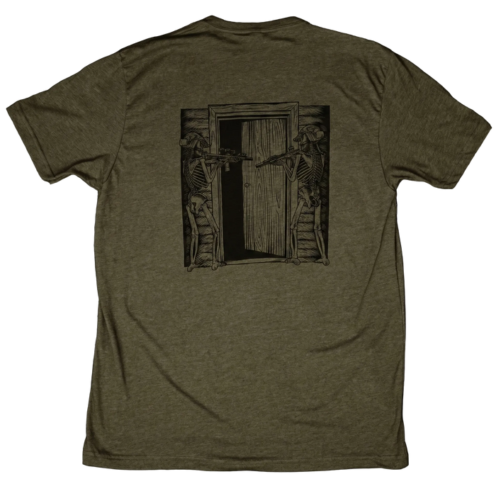 Green t-shirt with a graphic design of skeletons with rifles on a wooden door.