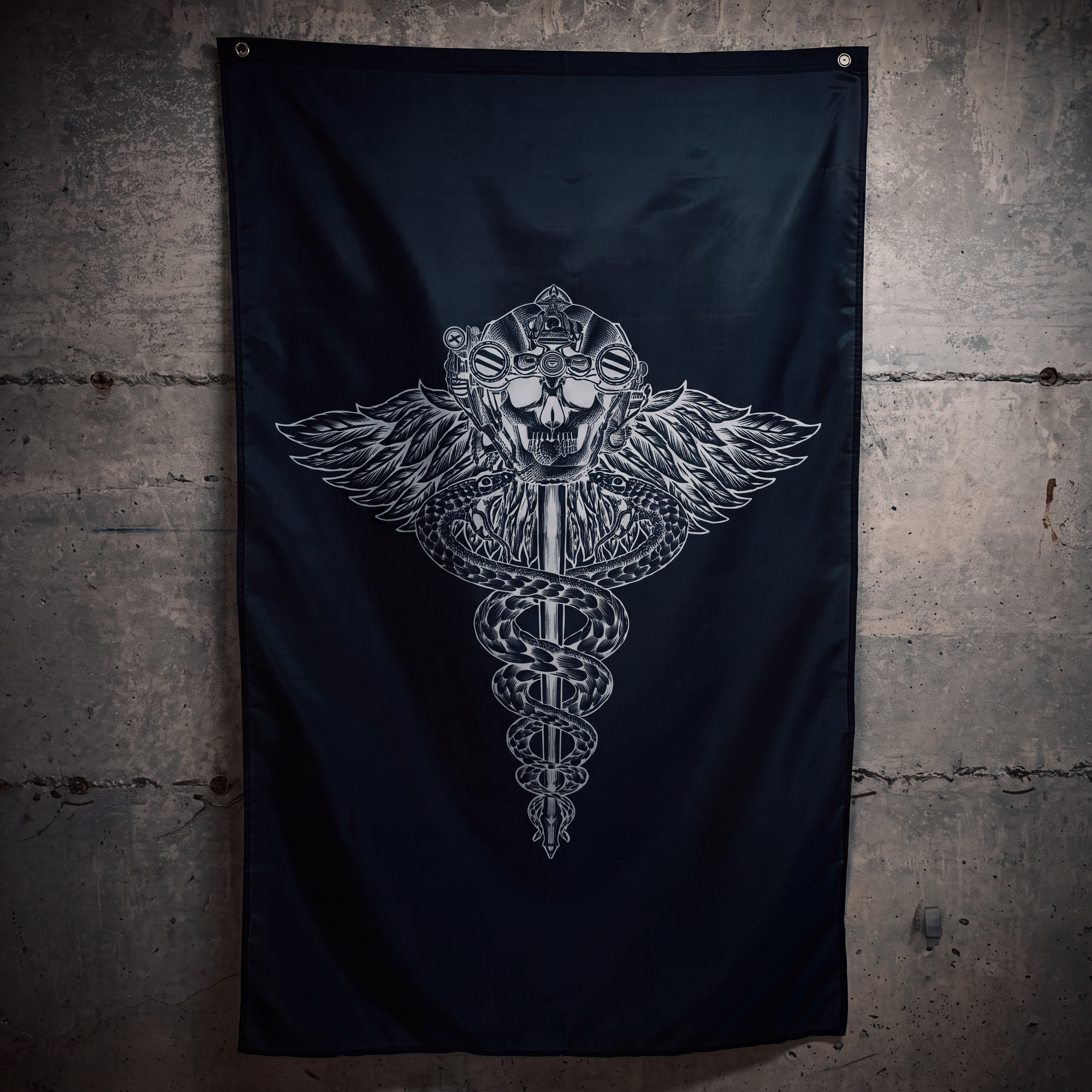 A black flag hanging on a textured concrete wall, featuring a large silver metallic graphic of a winged caduceus skull in the center.
